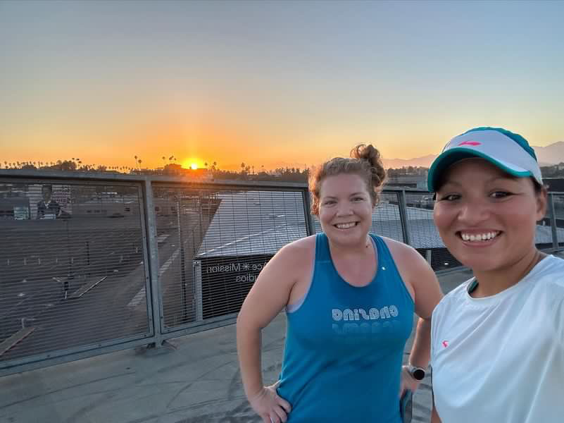 Vanessa and Kendra pose for a selfie in front of the sunrise. 