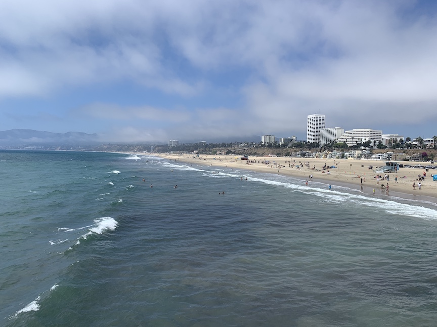 Santa Monica, as seen from the Santa Monica Pier (ocean in foreground, beach to right and mountains in the distance). 