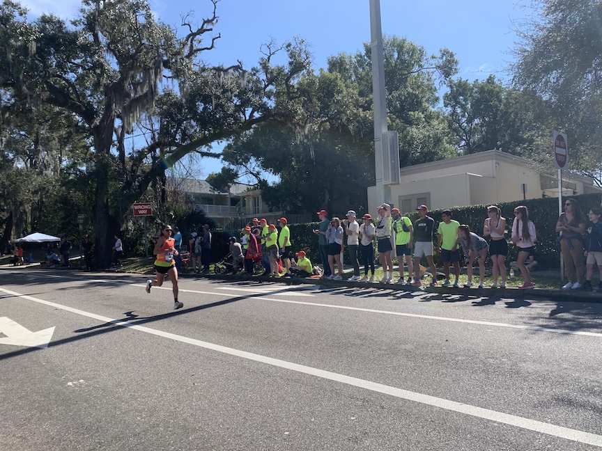 Des Linden running in the middle of the street with spectators to the right. 