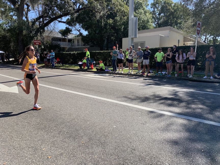 Eventual U.S. Olympic Marathon Trials winner Fiona O'Keeffe runs in the lead near Mile 25, with spectators cheering. 